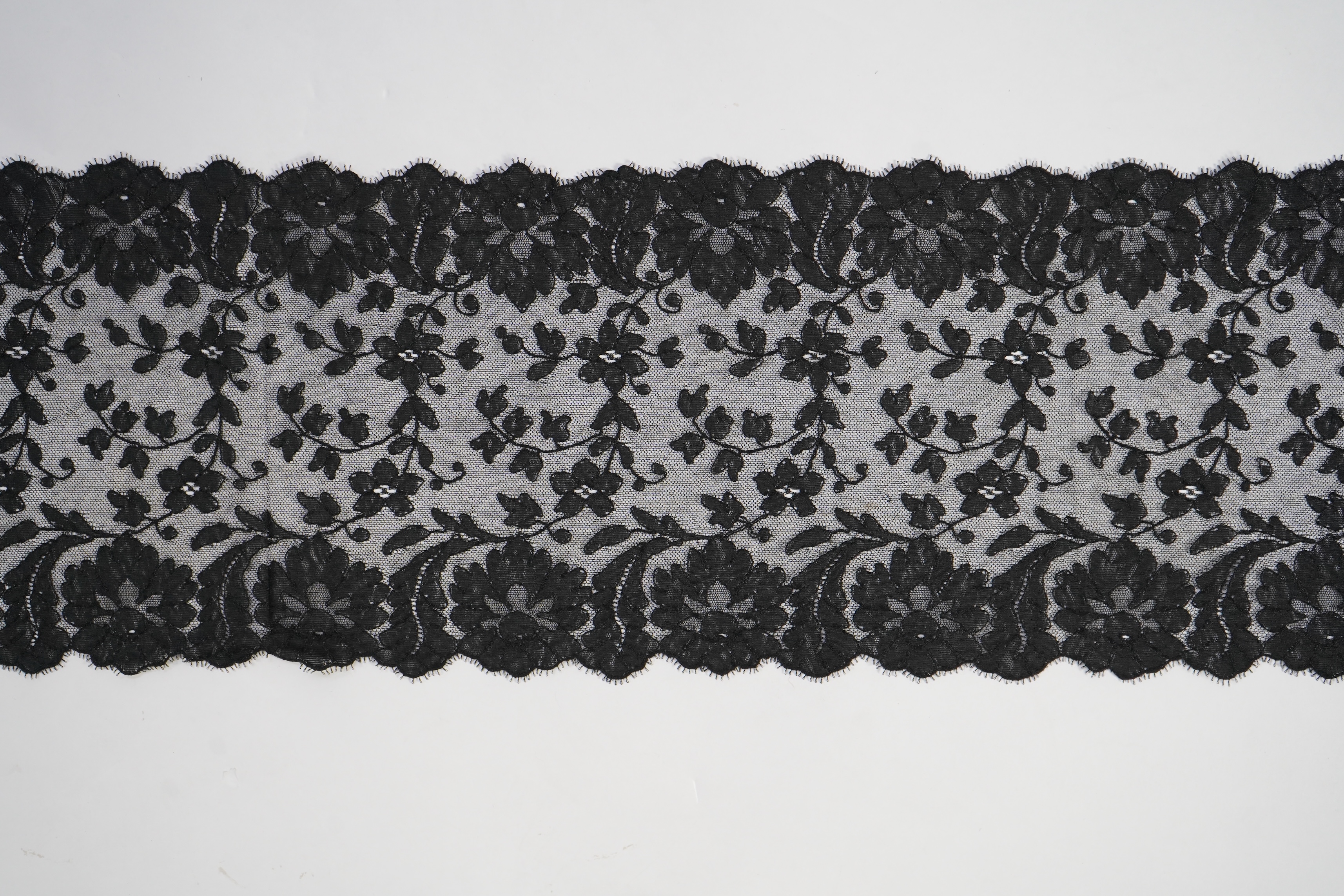 A collection of mixed machine lace: a black lace stole, two black veils, a sample of Japanese brocade, a length of metallic ribboning and various items of cream lace, ribboning 230cm long. Condition - variable poor to fa